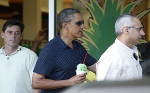 Flanked by Secret Service personnel, U.S. President Barack Obama carries a shave ice out of Island Snow near his vacation home in Kailua, Hawaii